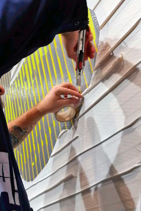 Live tape art by Selfmadecrew. Closeup of the hands, sticky tape and cutter knife