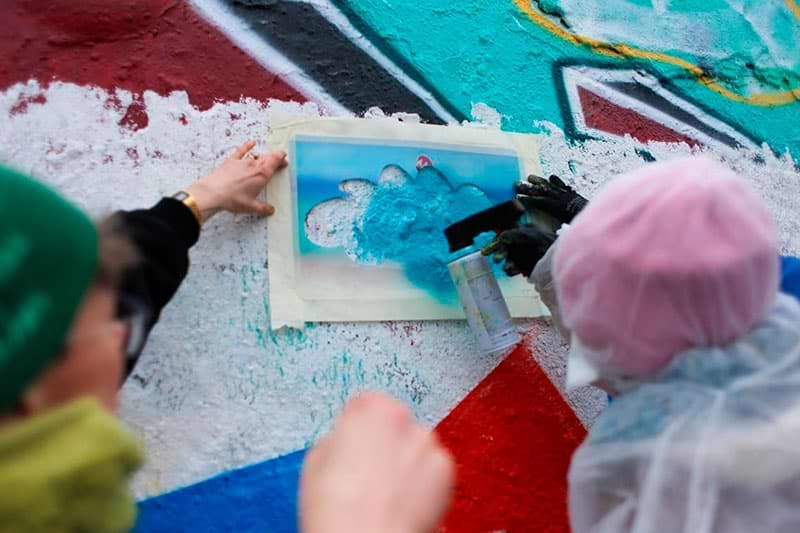 Schüler sprühen ein Schablonen Graffiti- Ein Workshop mit Ostap